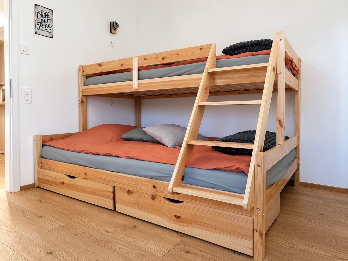 Uma cama beliche com escada, estrutura de madeira e várias almofadas.
