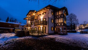 A multi-story building with balconies, a snow-covered ground, and a clear sky. - Hochkalter Vacation Rental (Schönau am Königssee)