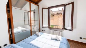 Une chambre à coucher avec un lit, une fenêtre, un radiateur et un plafond en bois.