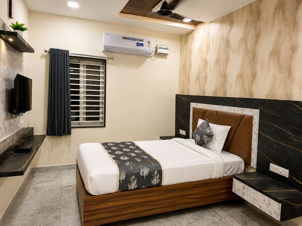 Un dormitorio moderno con una cama de madera, televisión integrada, ventana con cortinas y equipo de aire acondicionado.