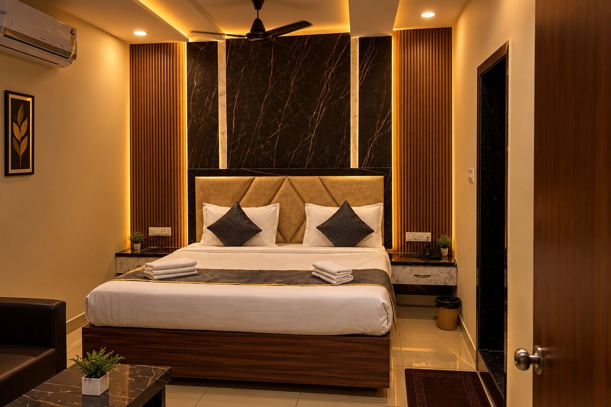 A modern hotel room with a large bed, a ceiling fan, and a marble floor.