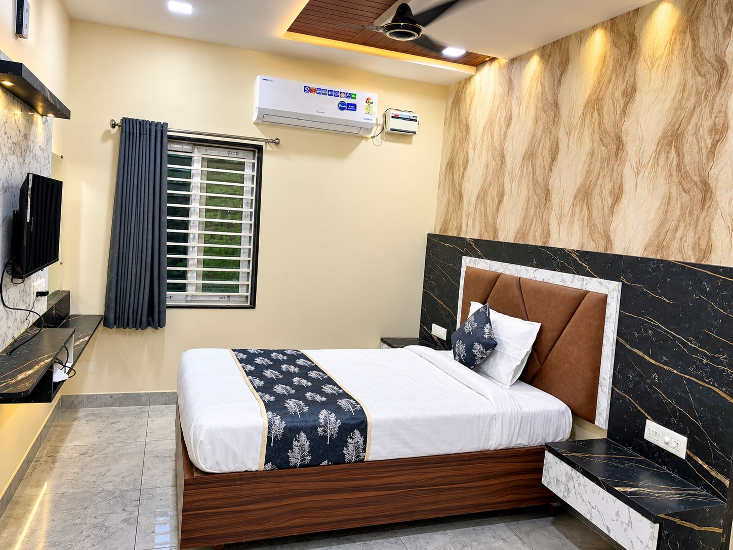 A modern bedroom with a bed, a TV, an air conditioning unit, and a window with curtains.