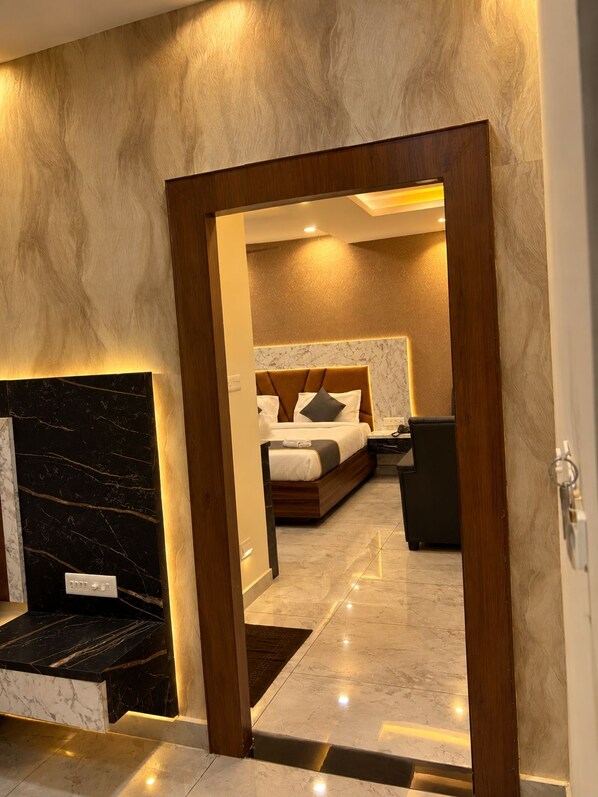 Habitación de hotel con cama, mesita de noche y una pared de acento de mármol.