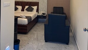 Una habitación de hotel compacta con una cama, zona de estar y una pequeña mesa.