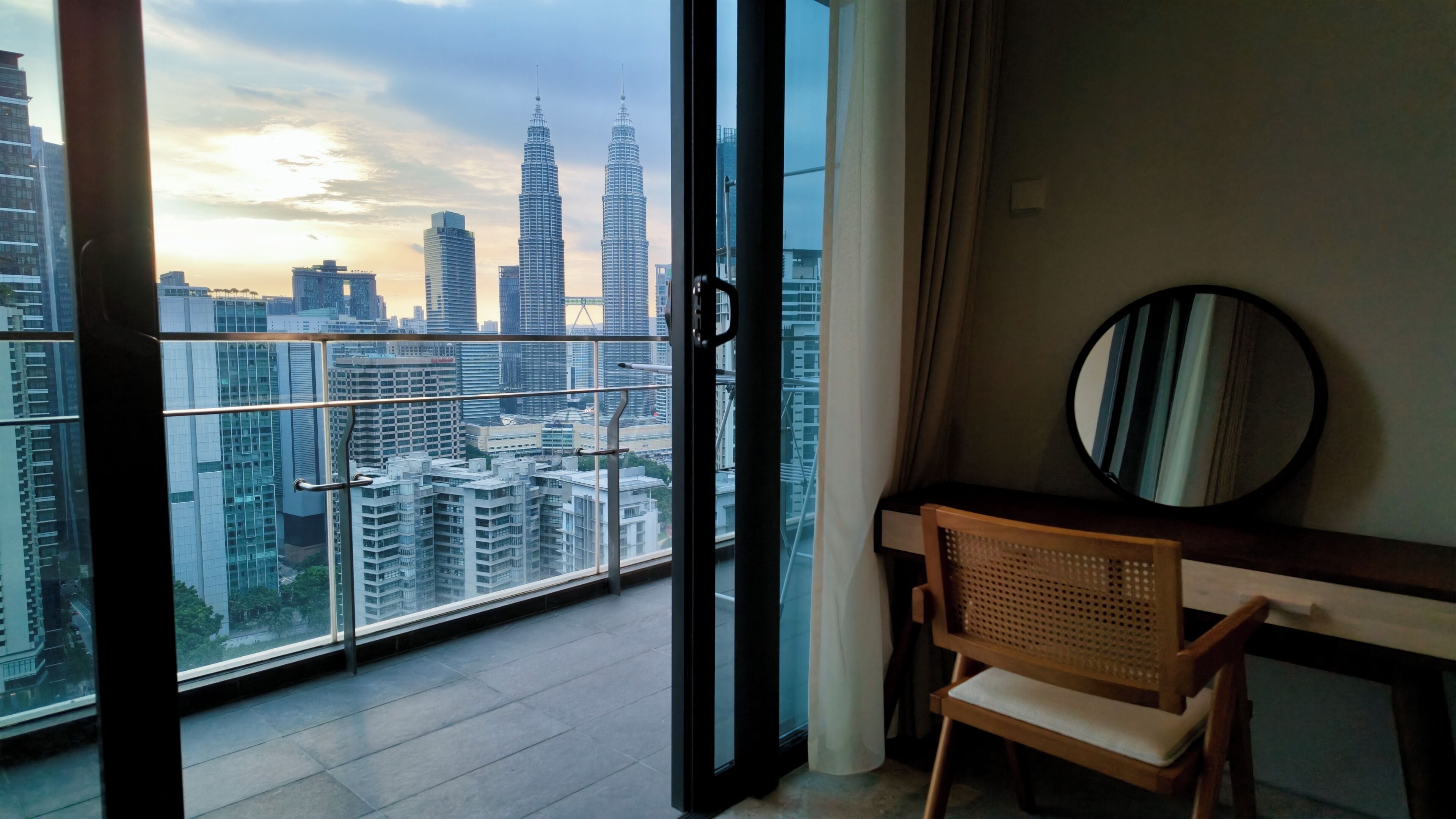 A balcony with a view of a city skyline, including tall buildings.