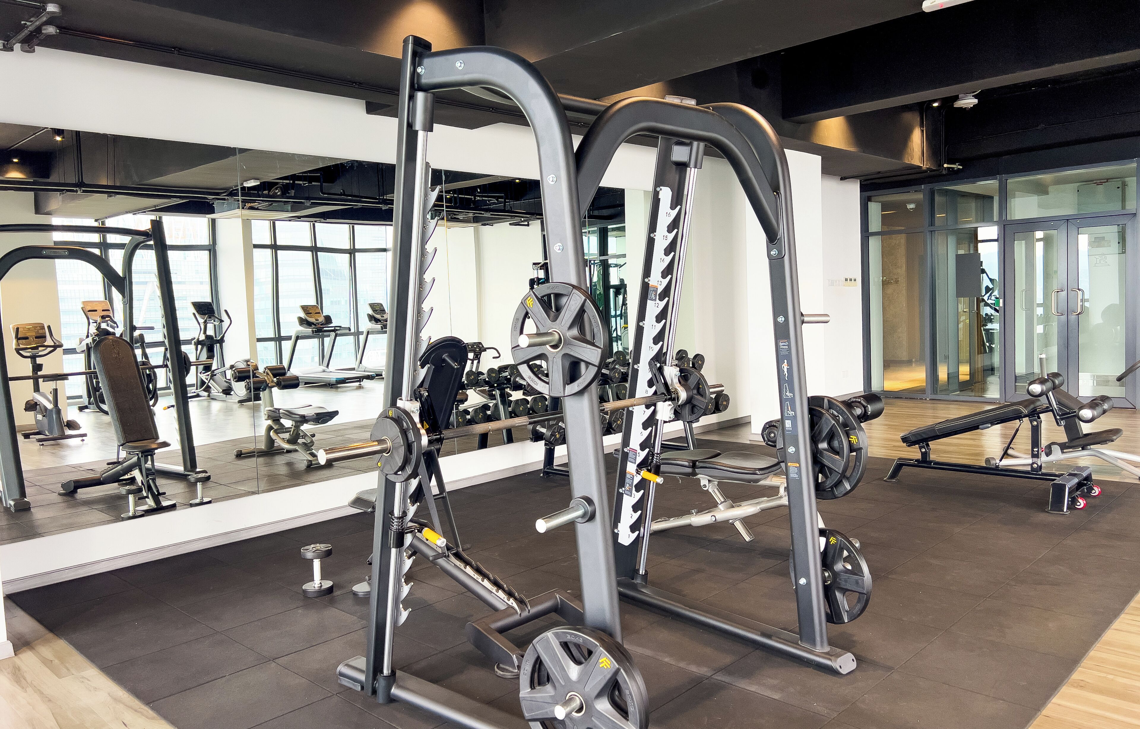 Un gimnasio con diverso equipo de ejercicio, incluyendo máquinas de pesas y pesas libres.
