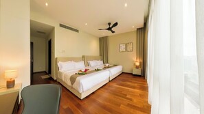 A hotel room with a double bed, a ceiling fan, a bedside table with a lamp, and a chair. - The Manor KLCC (Kuala Lumpur)
