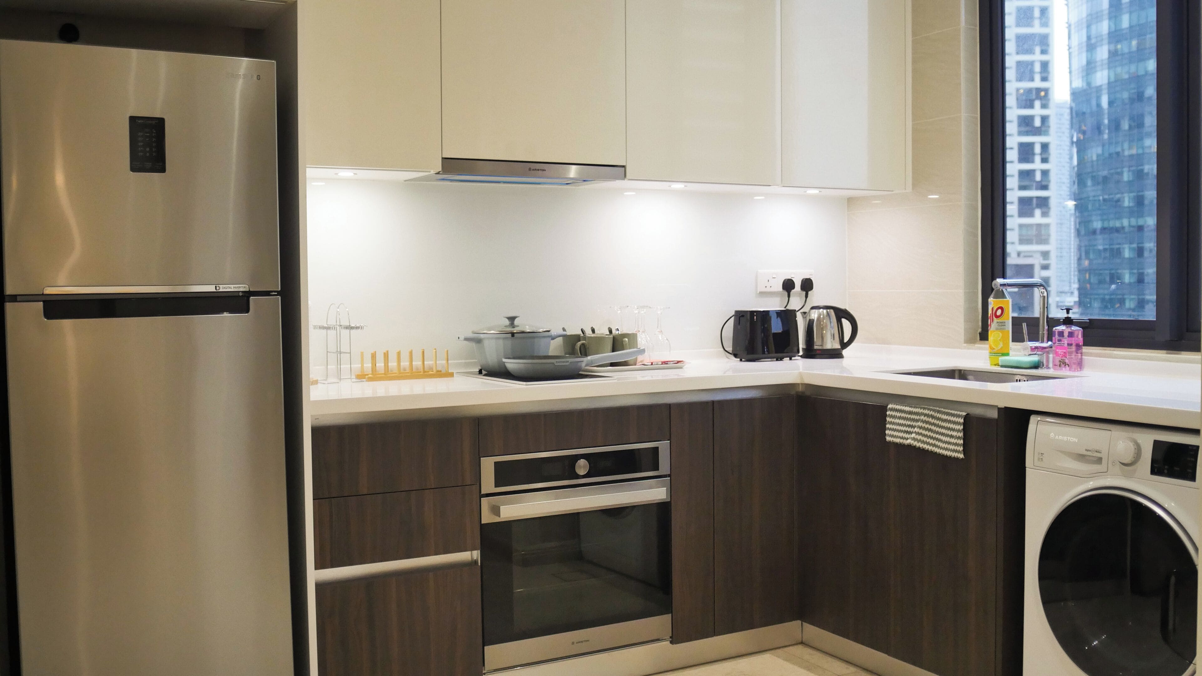 A modern kitchen with stainless steel appliances, a built-in oven, and a dishwasher.