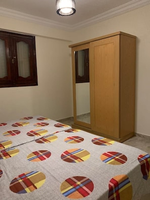 A room with a bed, a wardrobe, and a window with curtains. - Chalet in Horus Village and Golden Sands, North Coast (North Coast)