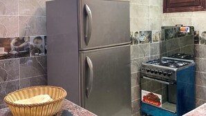 Une cuisine équipée d’un réfrigérateur en acier inoxydable, d’une cuisinière à gaz et d’un plan de travail en granit.