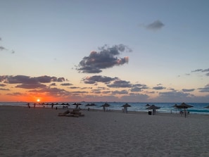A beach with umbrellas and a sunset. - Chalet in Horus Village and Golden Sands, North Coast (North Coast)