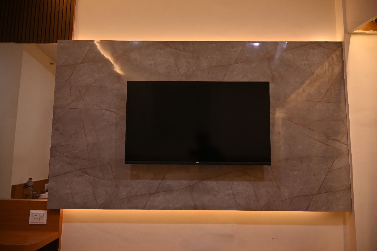 A flat-screen TV mounted on a wall with a marble-like texture.