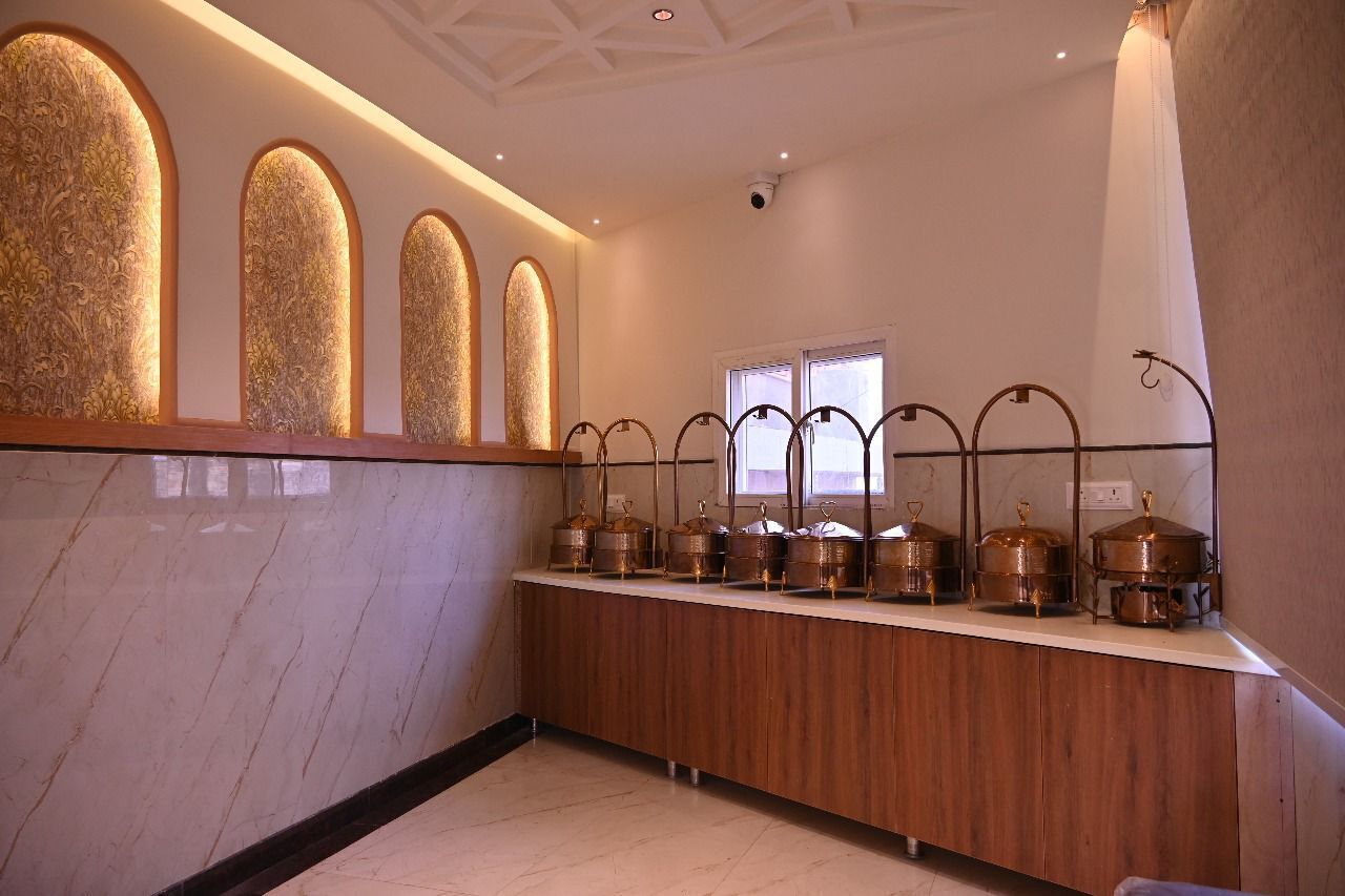A hotel reception area with a marble counter, ornate wall panels, and a window.