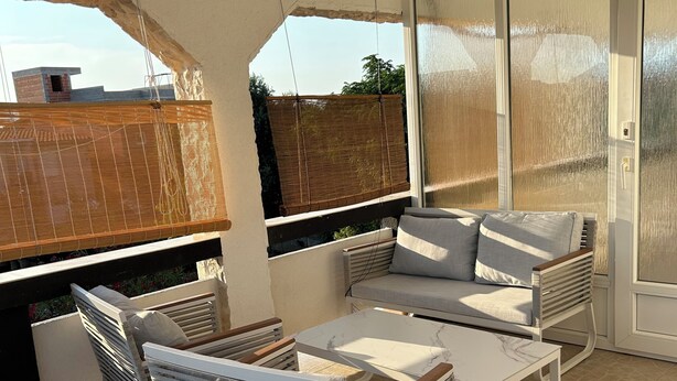 An outdoor patio area with a seating arrangement including a sofa and chairs, a table, and a view of the sky. - Relax and be well in this fresh apartment for 4 + Parking on the island of Vir (Vir)