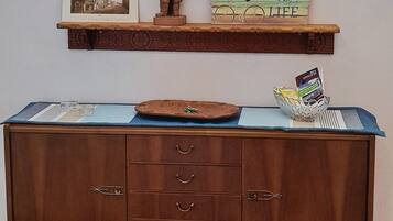 A wooden cabinet with drawers and a shelf above it.