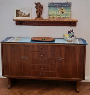 A wooden cabinet with drawers and a shelf above it.