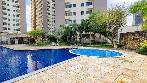 A residential building with a swimming pool, outdoor seating, and a stone wall. - CJC Short Stay Ecogarden (Natal)