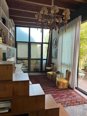 A spacious living room with a large window, a wooden ceiling, and a chandelier. - Lake of Varese, "Residenza Mirabella" (Gavirate)