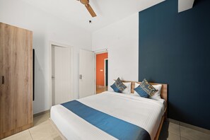 Ein Schlafzimmer mit einem Bett, einem Holzschrank und einem Deckenventilator.