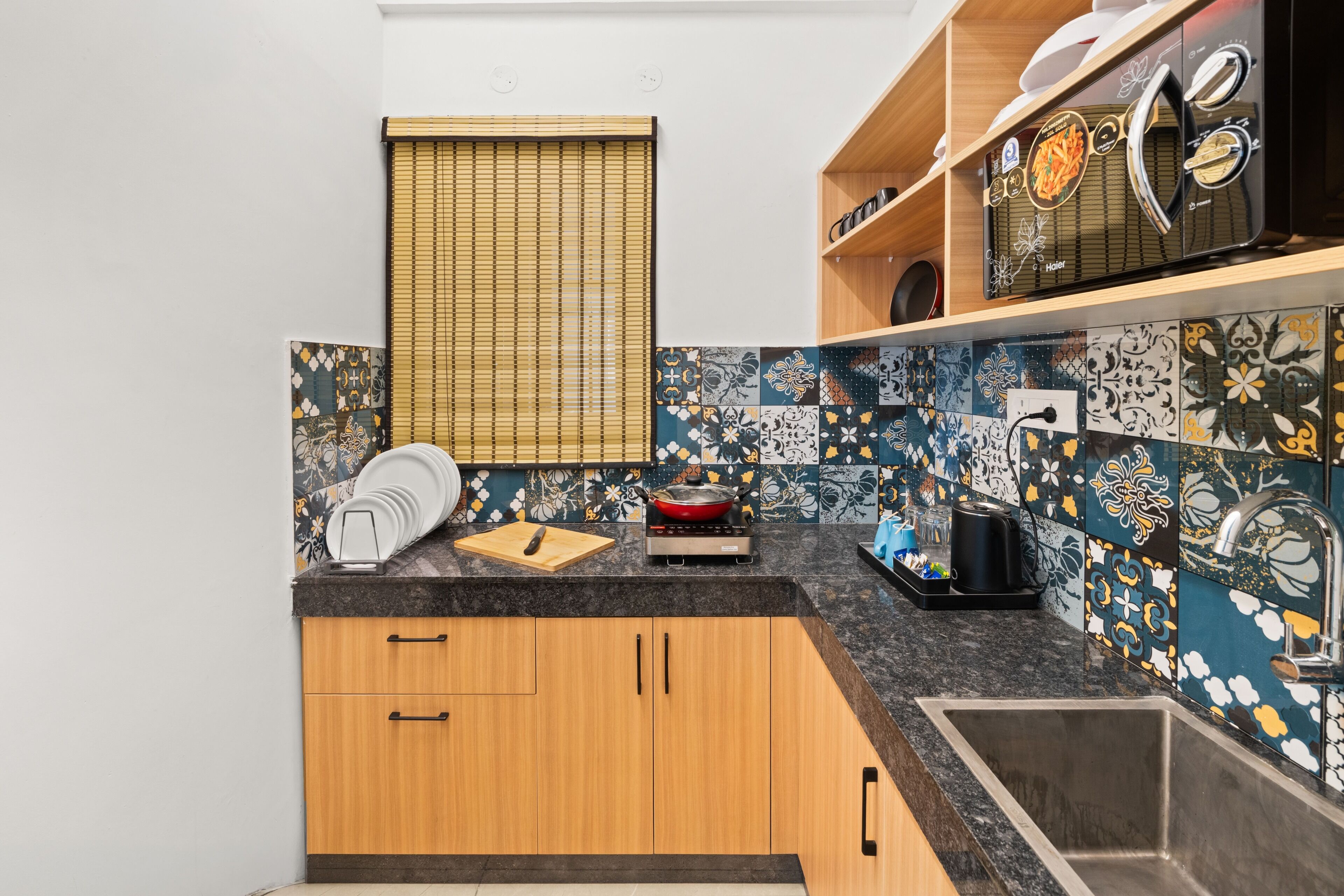 A kitchen with wooden cabinets, a stove, a sink, and a window with blinds.