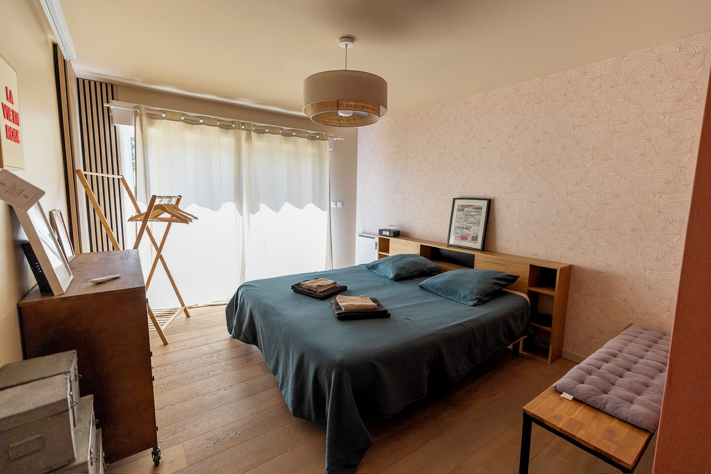 A bedroom with a bed, bedside table, and a chair.