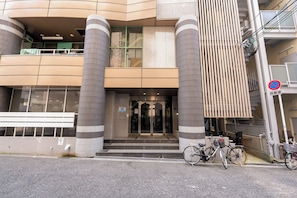 A modern building with a glass entrance, large pillars, and a no-parking sign. - b&Dotonbori 1 (Chuo Ward)