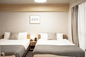 A hotel room with two beds, a nightstand with a lamp, and a framed picture on the wall. - b&Dotonbori 1 (Chuo Ward)