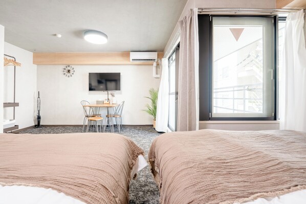 A hotel room with two beds, a TV, a desk with chairs, and a window with curtains. - b&Dotonbori 1 (Chuo Ward)