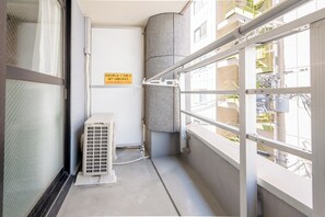 A narrow corridor with a window, a ventilation unit, and a sign in Japanese. - b&Dotonbori 1 (Chuo Ward)