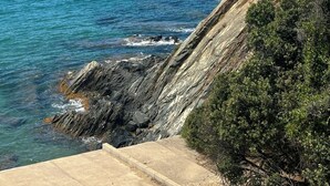 A coastal landscape with a clear view of the sea, rocky terrain, and distant landforms. - Vacation Apartment (La Croix-Valmer)