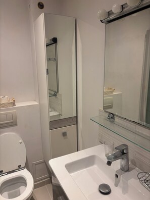 Ein modernes Badezimmer mit Toilette, einem Glaswaschbecken und einem Spiegel.