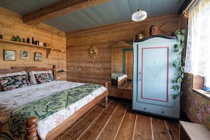 A wooden room with a bed, a wardrobe, and a mirror. - Dom Dobrego Lata – Historic House in Żuławy (Drewnica)
