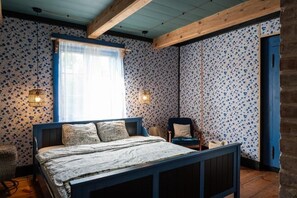 Ein Schlafzimmer mit einem Bett, einem Sessel, einer Lampe und einem Kleiderschrank.
