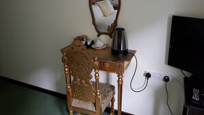 A small wooden desk with a mirror, a kettle, and a power outlet. - Dolbrodmaeth Riverside  (Machynlleth)