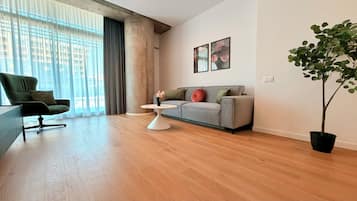 Uma sala de estar moderna com sofá, poltrona, mesinha de centro e planta em vaso.