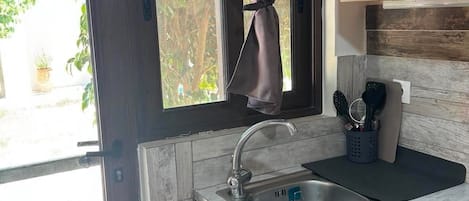 A kitchen with a window, a sink, and wooden cabinets.