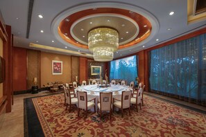 Un comedor formal con una mesa redonda, sillas y una araña.