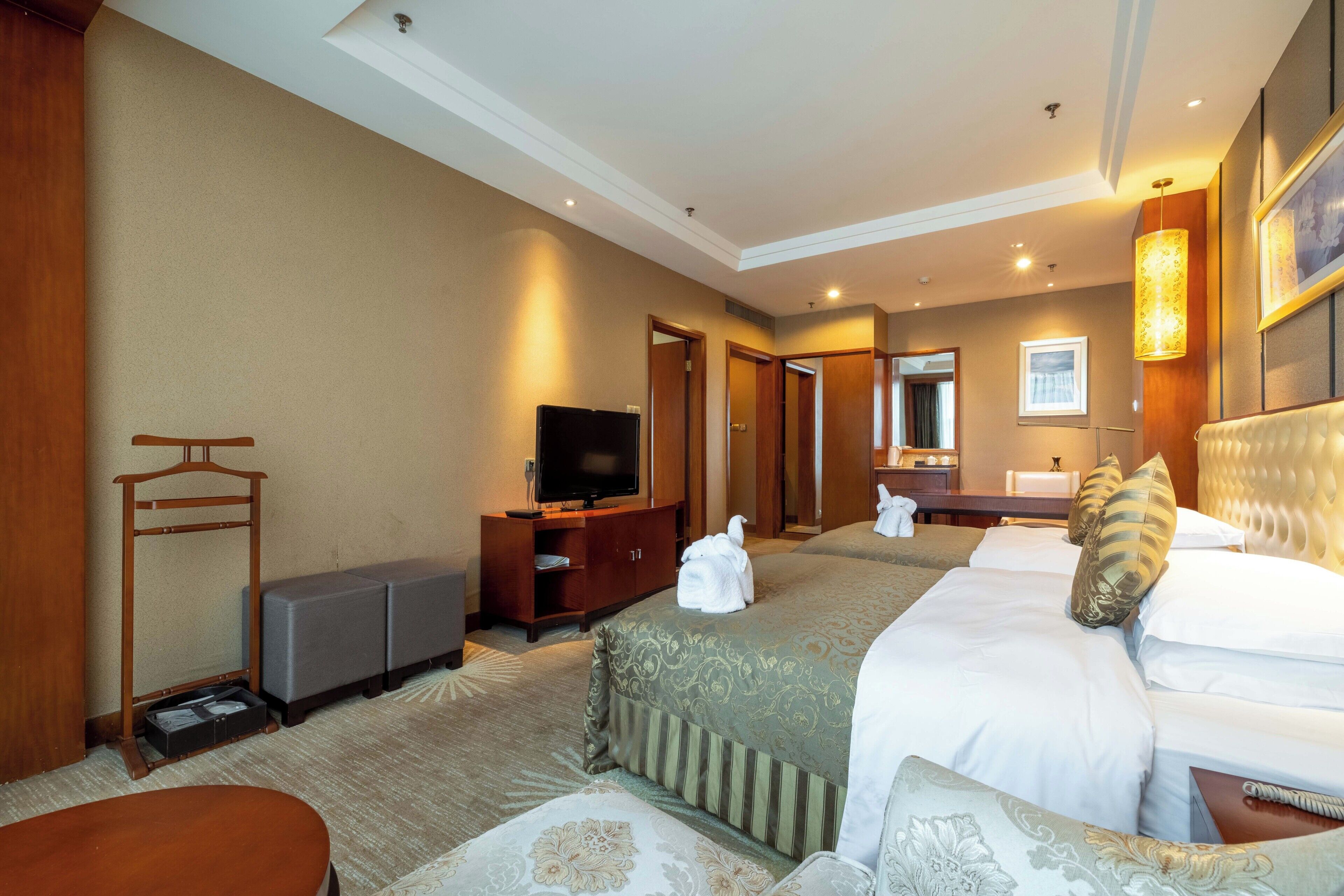 A hotel room with a bed, a television, a desk, and a bathroom.