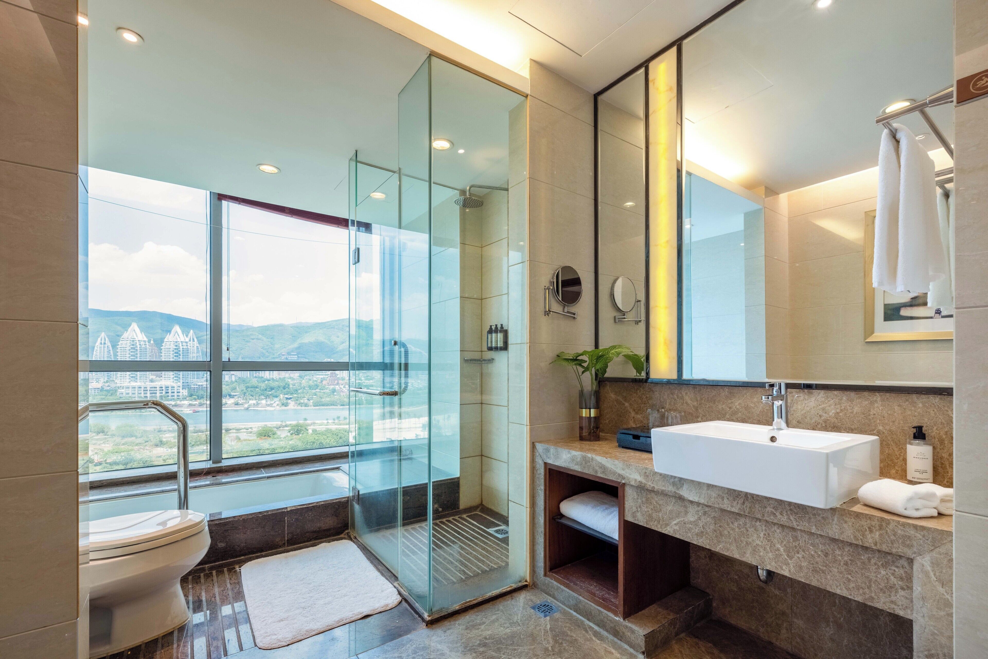 A modern bathroom with a glass-enclosed shower, a sink, and a large mirror.