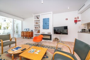 Ein modernes Wohnzimmer mit Kamin, Fernseher und Essbereich mit Tisch und Stühlen.