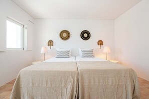 A double bed with two pillows, a bedside table with a lamp, and wall decor. - Les Terrasses B / Private Rooftop Pool in Tavira (tavira)