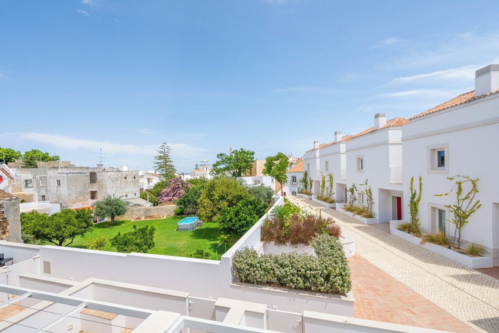 Un quartier résidentiel avec des bâtiments blancs, une piscine et un jardin bien entretenu.