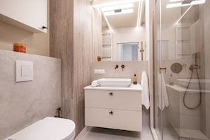 A modern bathroom with a toilet, sink, and shower area. - Kierbedzia Harmony Premium, Free Parking & WiFi (Warszawa)
