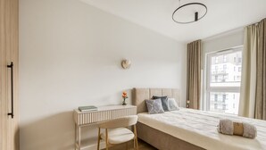 Ein schlicht eingerichtetes Schlafzimmer mit Bett, Schreibtisch und Stuhl.