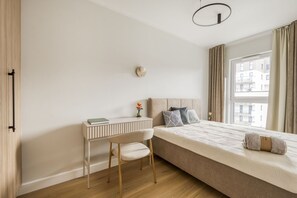 A minimalist bedroom with a bed, a desk, and a chair. - Kierbedzia Harmony Premium, Free Parking & WiFi (Warszawa)