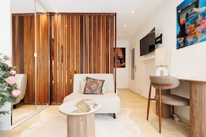 A modern living room with a sofa, a coffee table, a desk, and a TV mounted on the wall. - 140m from the Palace of Festivals #Croisette #city center #air conditioning #Wi-Fi #elevator #terrace (Cannes)