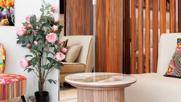 A room with a beige sofa, a round marble table, and a potted plant with pink flowers. - 140m from the Palace of Festivals #Croisette #city center #air conditioning #Wi-Fi #elevator #terrace (Cannes)