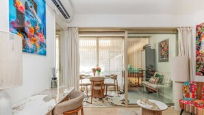A modern living room with a dining area, a sofa set, and a large window with curtains. - 140m from the Palace of Festivals #Croisette #city center #air conditioning #Wi-Fi #elevator #terrace (Cannes)