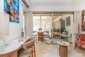 A modern living room with a dining area, a sofa set, and a large window with curtains. - 140m from the Palace of Festivals #Croisette #city center #air conditioning #Wi-Fi #elevator #terrace (Cannes)