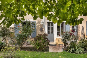 A residential property with a garden, a pathway leading to the entrance, and a blue door.